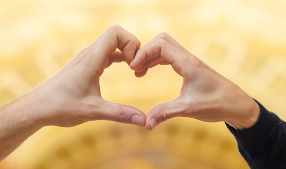 Foto von zwei Händen von verschiedenen Personen, die zusammen ein Herz bilden.