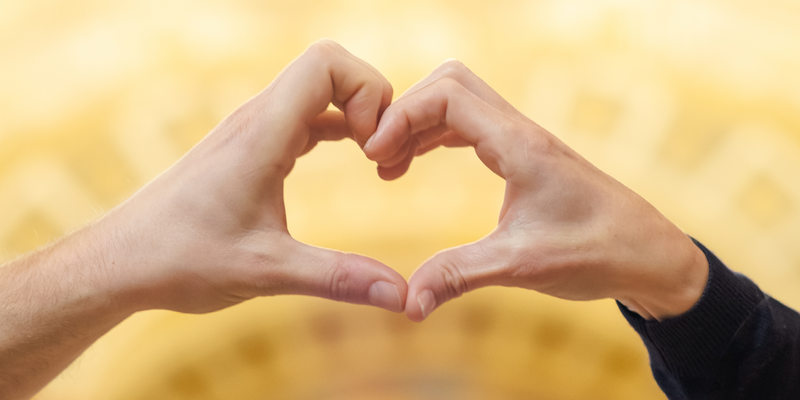 Valentinstag.png Foto von zwei Händen von verschiedenen Personen, die zusammen ein Herz bilden.