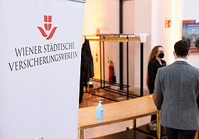 Garderobe, daneben ein Ständer mit dem Logo des Wiener Städtische Versicherungsvereins