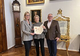 rachinger_konrad.jpg Drei Personen halten eine Urkunde.