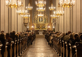 01_augustinerkirche.jpg Menschen sitzen in einer Kirche.