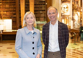Johanna_Rachinger_Heimo_Scheuch.jpg Zwei Personen stehen in Marmorsaal mit Bücherregalen.
