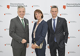 2_corporate_lunch_2023.jpg Drei Personen posieren vor Logowand.