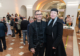 Mark_Benecke_Gattin_Ines.jpg Zwei elegant gekleidete Personen posieren für ein Foto.