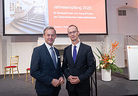 Gerald_Beck_Richard_Starkel.jpg Zwei Personen stehen beim Jahresempfang 2025 der Österreichischen Nationalbibliothek vor der Präsentationsleinwand.