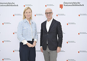 8_corporate_lunch_2023.jpg Zwei Personen posieren vor Logowand.