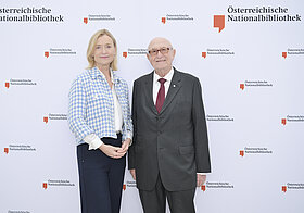 7_corporate_lunch_2023.jpg Zwei Personen posieren vor Logowand.