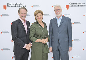 9_corporate_lunch_2023.jpg Drei Personen posieren vor einer Logowand.