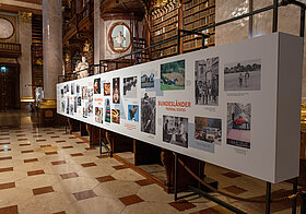 23_okamoto.jpg Foto von langer Wand mit aufgedruckter Ausstellung.