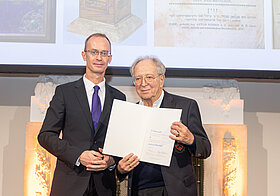 Richard_Starkel_Thomas_Lachs.jpg Zwei elegant gekleidete Personen posieren mit einer Urkunde