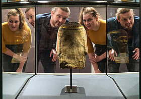 Papyrusmuseum_1 Two people are looking at an ancient Egyptian mummy mask